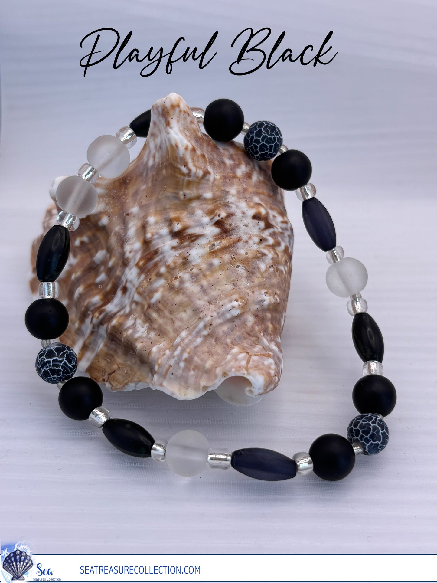 Bracelet with black and clear beads on a shell against a light gray background
