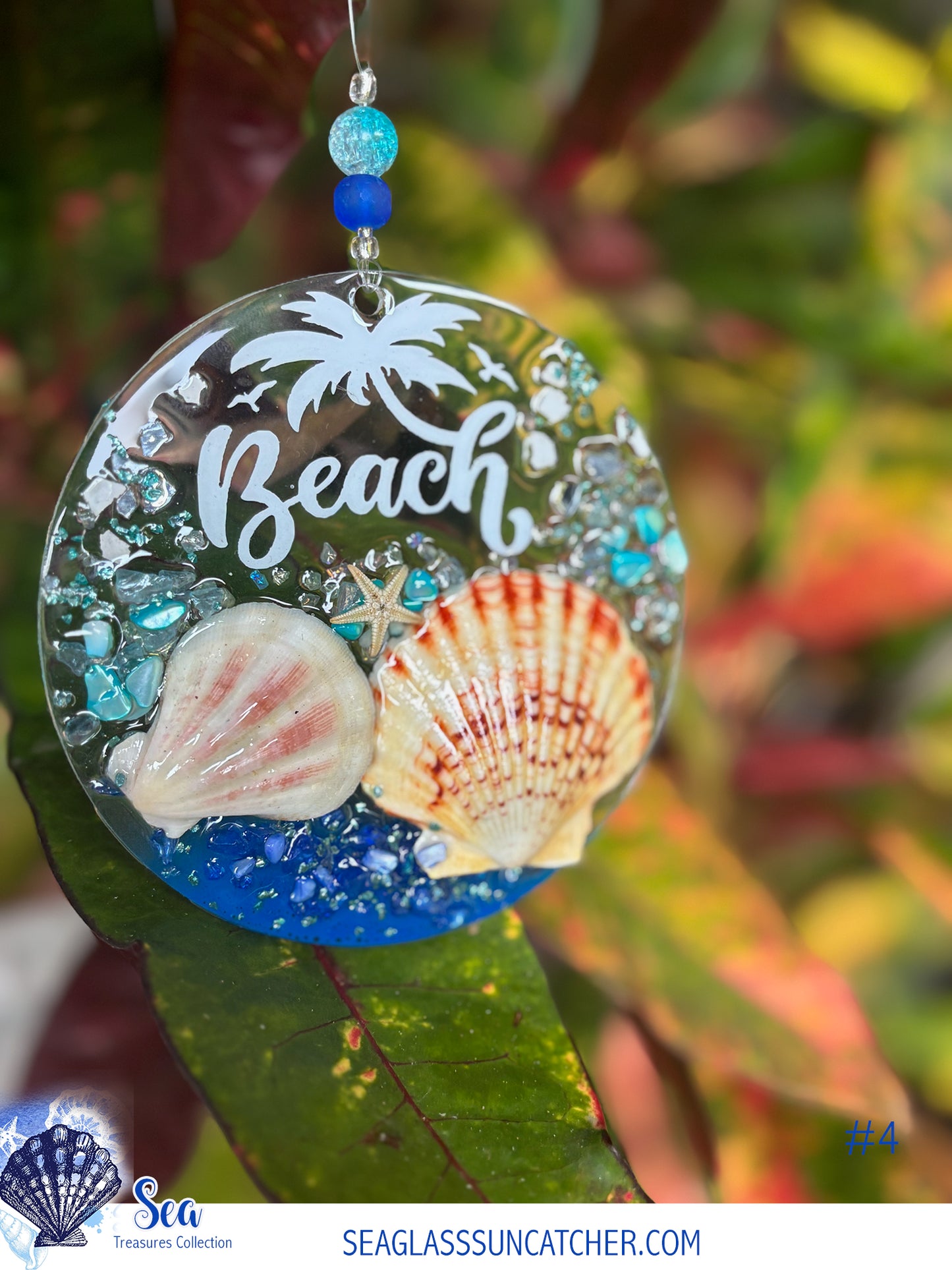 Decorative beach-themed suncatcher with shells and 'Beach' text on a blurred natural background.
