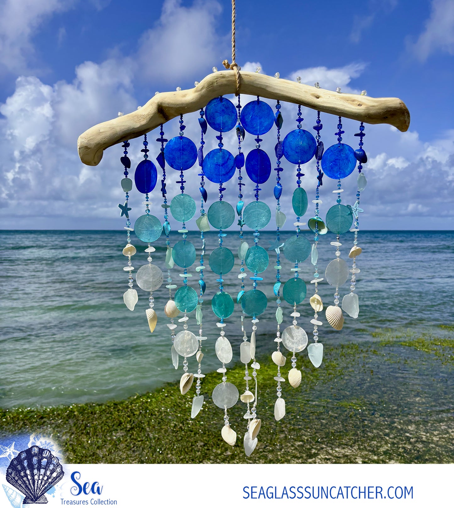 Seaglass sun catcher with blue and white beads against a beach backdrop