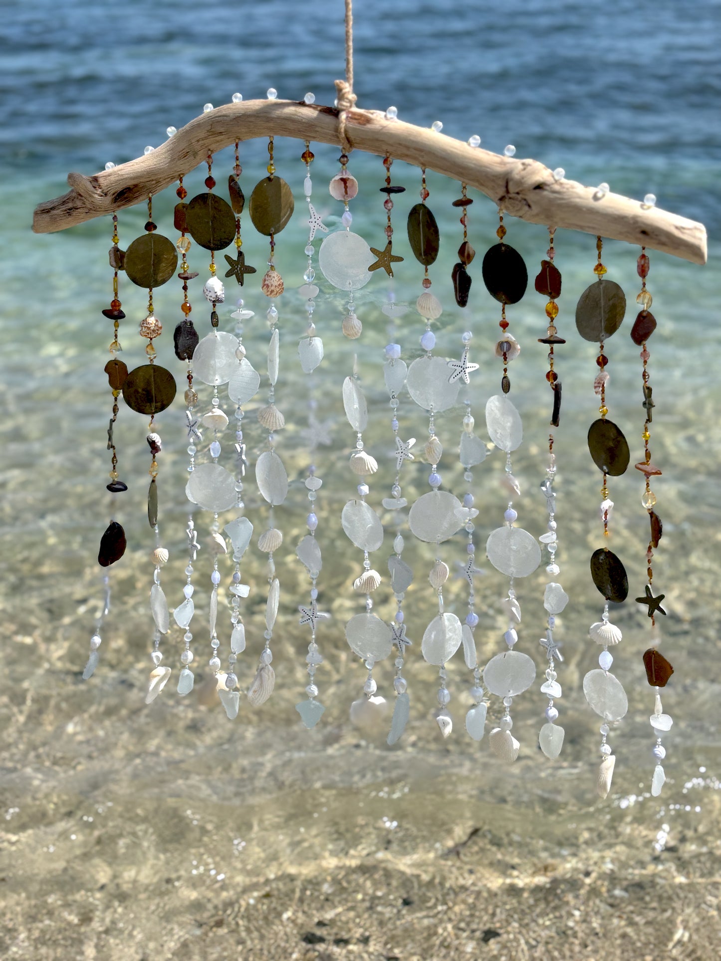 Decorative wind chime with natural elements on a beach