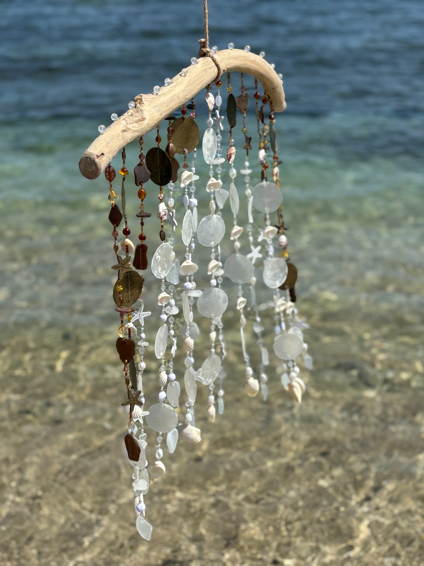 Decorative wind chime with natural elements on a beach