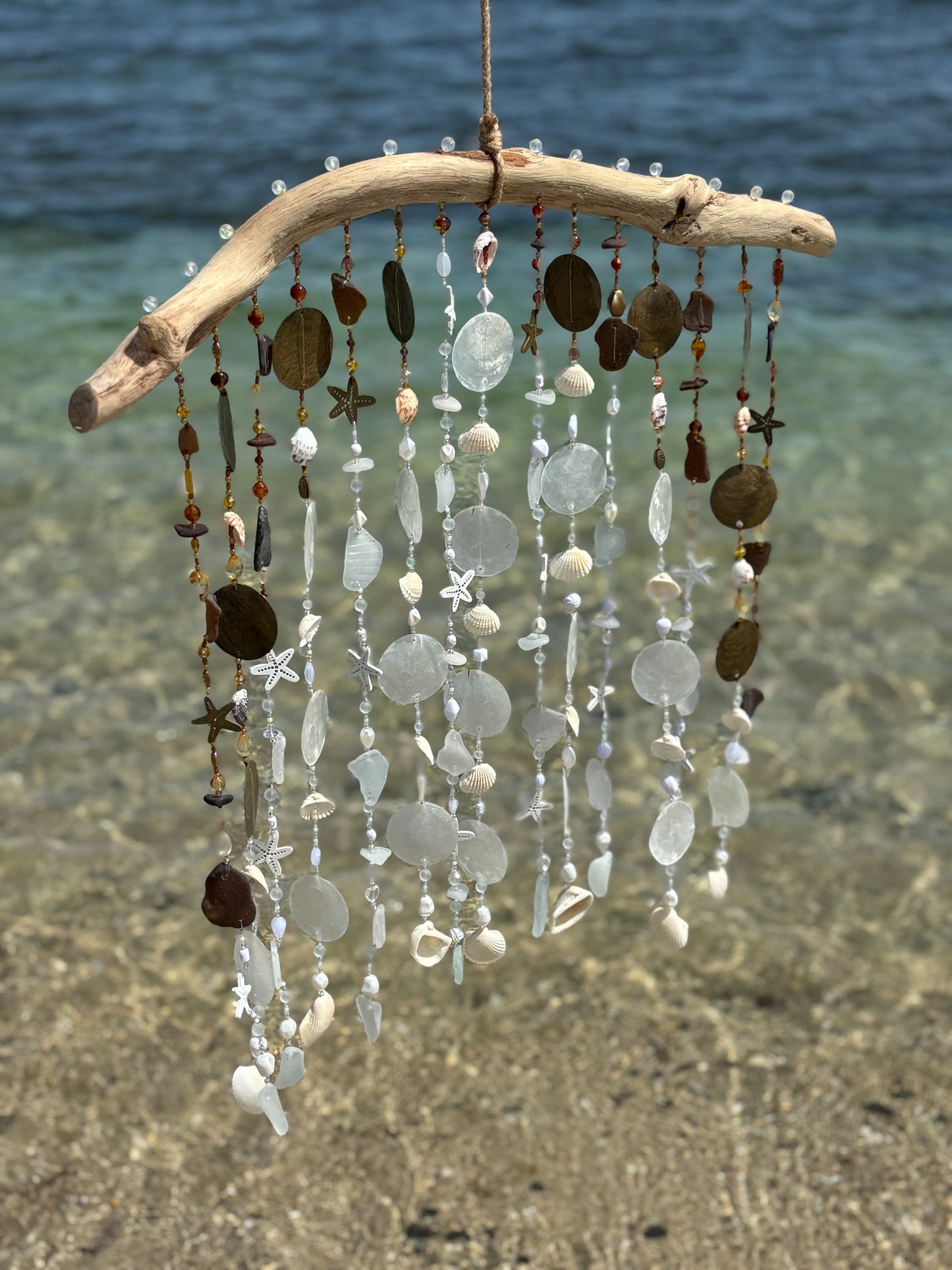 Tropical wind chime with natural elements on a beach
