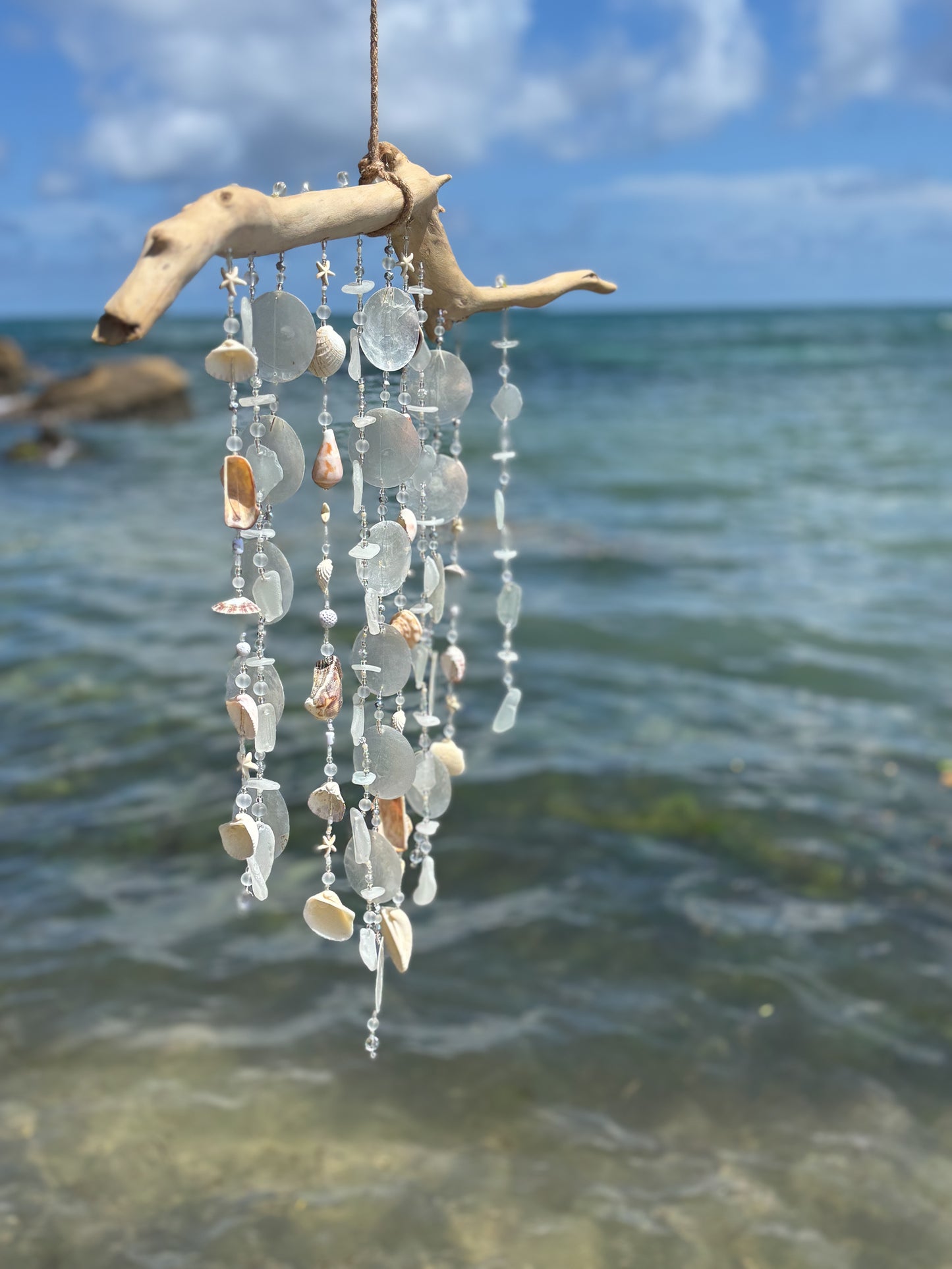 white seaglass wind chime on driftwood