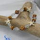 Bracelet with starfish and wooden bead design on a branch, featuring 'Sea Treasures Collection' branding.