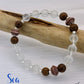 Bracelet with white beads and brown wooden beads on a white background