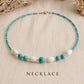 Handmade Caribbean Blue necklace featuring turquoise beads, white wooden beads and stainless steel accents inspired by the Caribbean Sea.