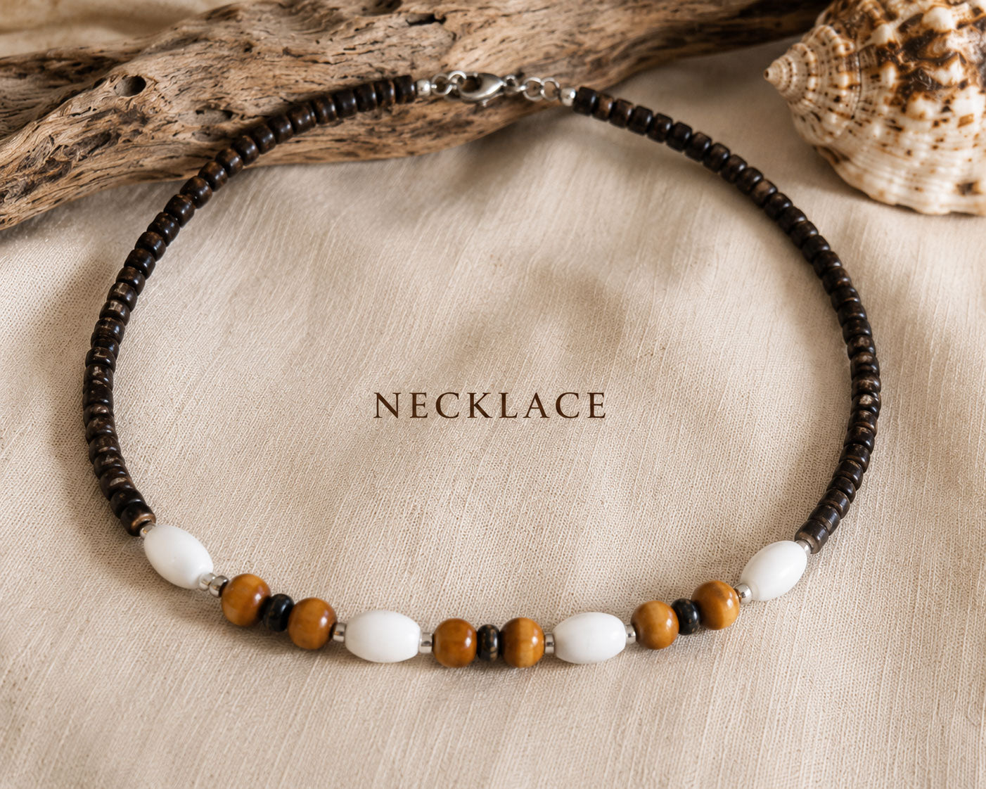 Close-up of the Island Drift handmade necklace with coconut beads, wood beads, white accents and stainless steel details.
