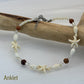 Beaded anklet with starfish and shell designs on a wooden branch