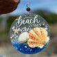 Decorative seaglass suncatcher with 'Beach Vibes' text, shells, and a starfish against a blurred beach background.