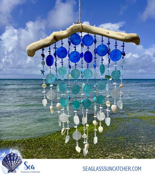 Seaglass sun catcher with blue and white beads against a beach backdrop