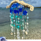 Decorative wind chime with blue and white beads on a beach