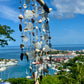 Seaglass sun catcher with a scenic view of a harbor and cityscape in the background.