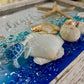 Decorative tray with turtle, shells, and starfish on a blue and white background