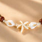 Close-up of the Island Star necklace featuring natural shells, starfish and handcrafted beadwork.