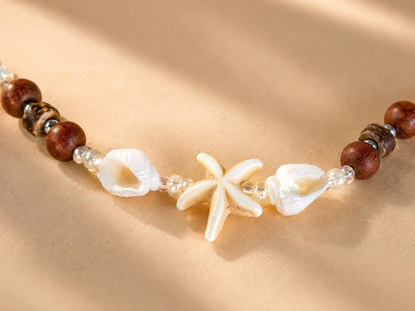 Close-up of the Island Star necklace featuring natural shells, starfish and handcrafted beadwork.