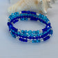 Set of blue beaded bracelets on a white surface with seashells in the background