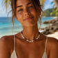 Woman wearing the Island Star shell necklace handcrafted in Grenada with white glass beads and natural shells.