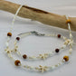 Necklace with starfish and wooden bead elements on a white background