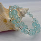 Turquoise beaded bracelet with silver accents on a shell background