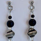 Pair of earrings with black and gray beads on a white background
