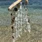 Decorative wind chime with natural elements on a beach