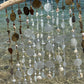 Decorative hanging with seaglass and shells by a body of water