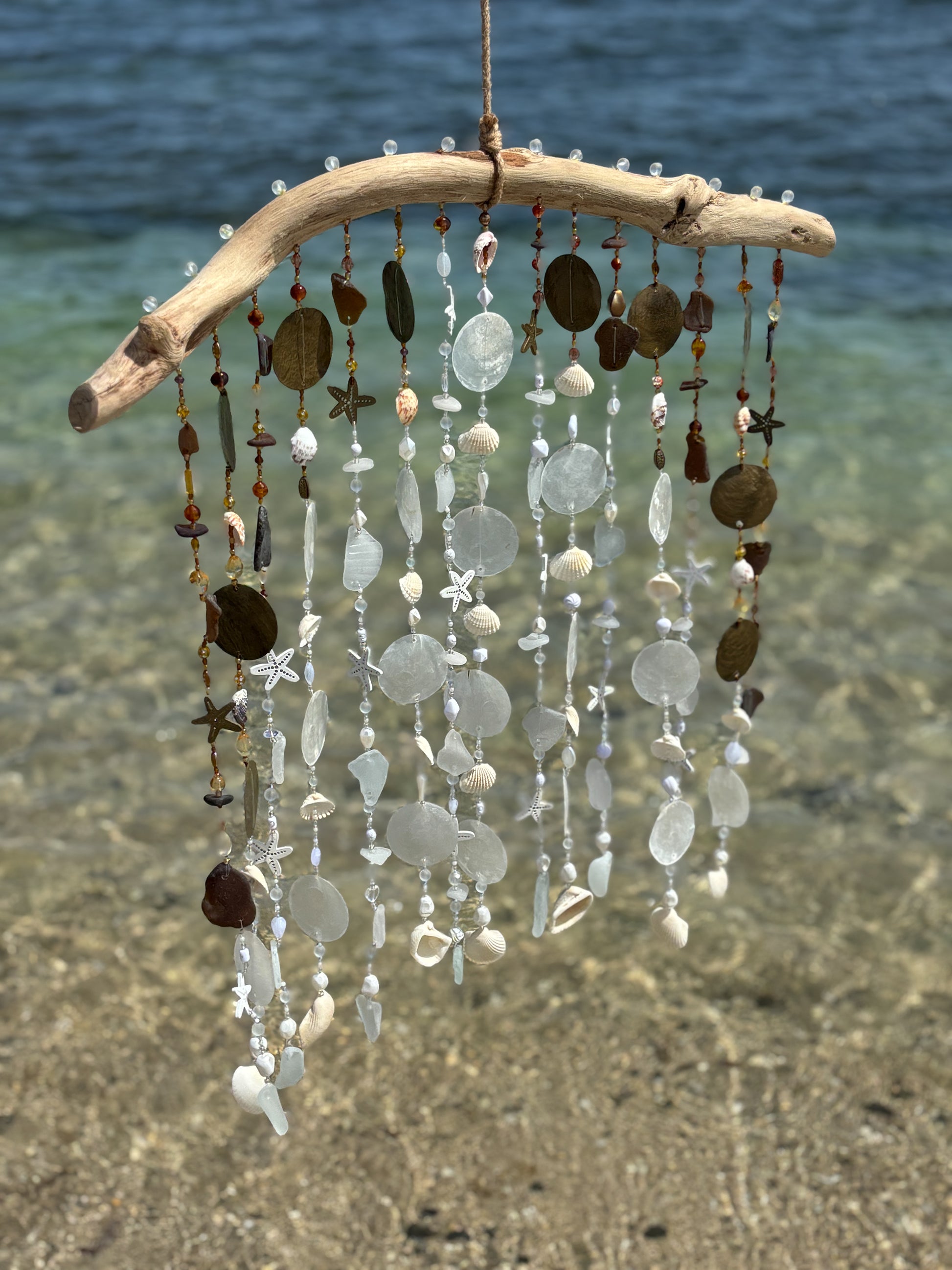 Tropical wind chime with natural elements on a beach