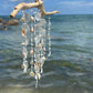 white seaglass wind chime on driftwood
