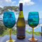 Cape Spring wine bottle with two blue and green patterned wine glasses outdoors.
