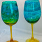 Two turquoise and gold wine glasses on a white background