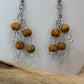 Pair of earrings with wooden beads and clear beads on a white background